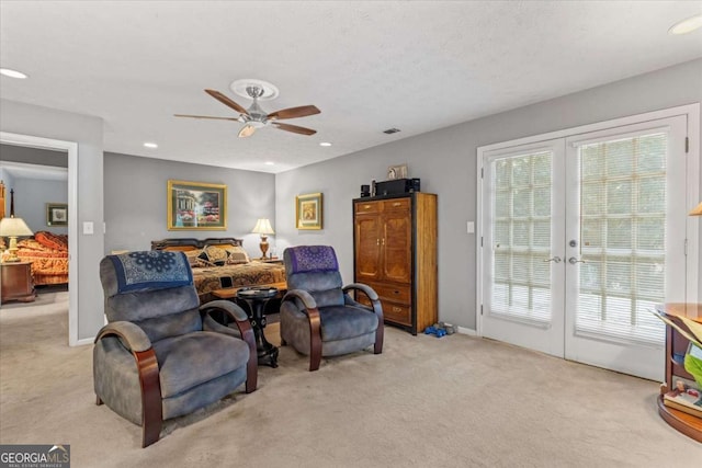 carpeted living room featuring french doors and ceiling fan