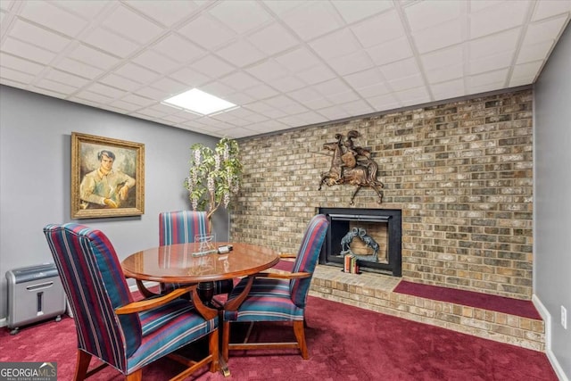 carpeted dining room with a brick fireplace