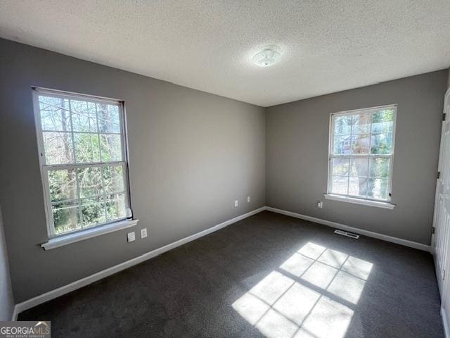 carpeted empty room with a textured ceiling