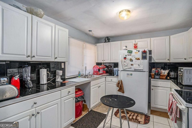 kitchen featuring light tile patterned floors, white appliances, decorative backsplash, and white cabinets