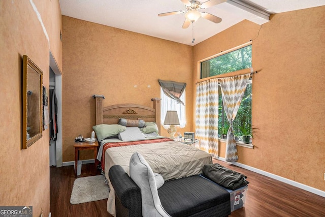 bedroom with ceiling fan, dark hardwood / wood-style floors, and vaulted ceiling with beams