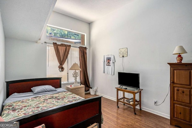 bedroom featuring hardwood / wood-style flooring and a textured ceiling