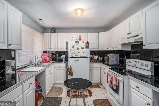 kitchen featuring sink, tasteful backsplash, light tile patterned floors, white appliances, and white cabinets