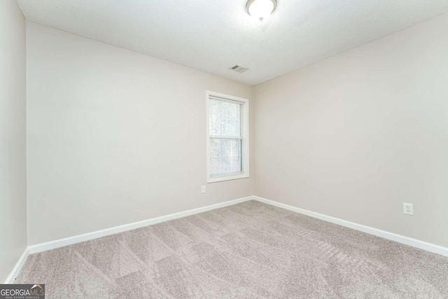 empty room featuring carpet and a textured ceiling