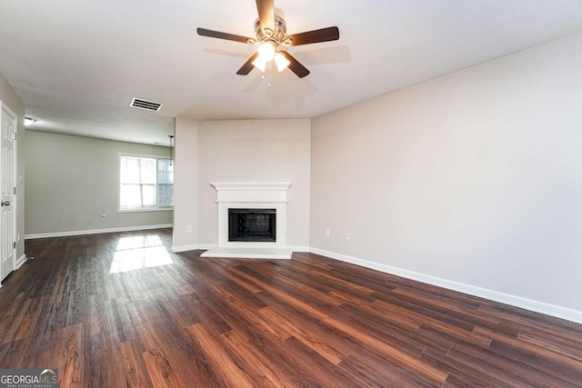 unfurnished living room featuring ceiling fan and dark hardwood / wood-style flooring