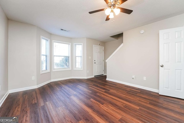 empty room featuring ceiling fan, dark hardwood / wood-style flooring, and a textured ceiling