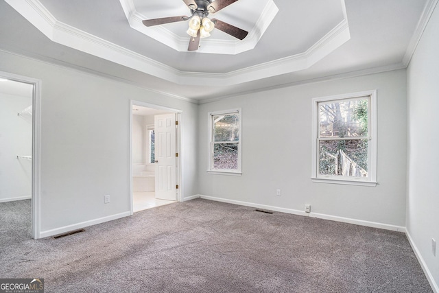 spare room featuring ceiling fan, carpet flooring, ornamental molding, and a tray ceiling