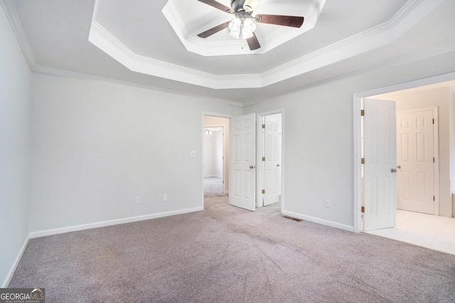 unfurnished bedroom with ceiling fan, crown molding, light carpet, and a raised ceiling