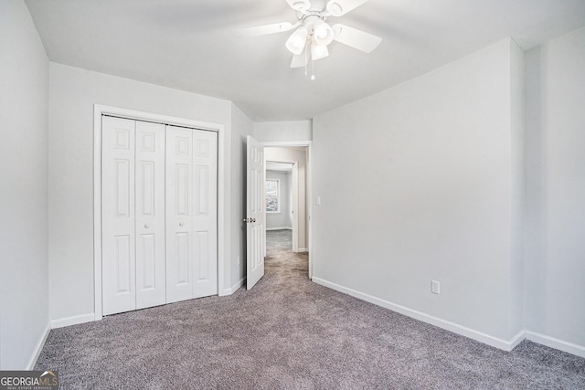 unfurnished bedroom featuring ceiling fan, a closet, and carpet floors