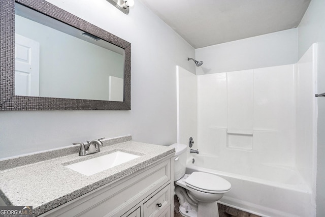 full bathroom featuring toilet, hardwood / wood-style floors, bathing tub / shower combination, and vanity