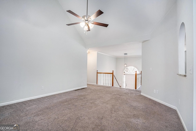 carpeted empty room with high vaulted ceiling and ceiling fan