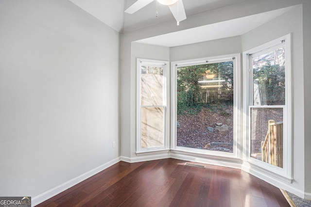 spare room with ceiling fan, vaulted ceiling, and dark hardwood / wood-style floors