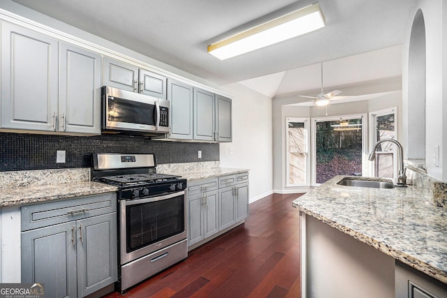 kitchen featuring appliances with stainless steel finishes, backsplash, gray cabinetry, and sink