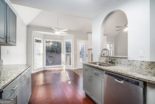 kitchen with sink, gray cabinetry, stainless steel dishwasher, and lofted ceiling