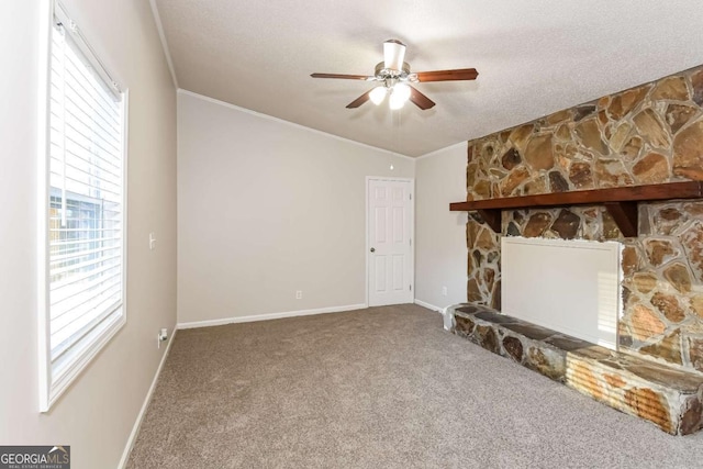 unfurnished living room featuring vaulted ceiling, carpet flooring, ceiling fan, ornamental molding, and a textured ceiling