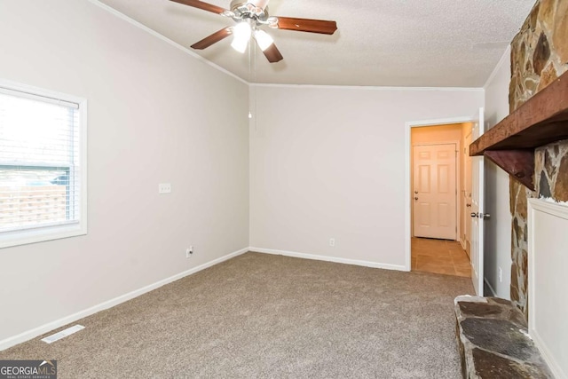 unfurnished living room with carpet, a textured ceiling, ceiling fan, and ornamental molding