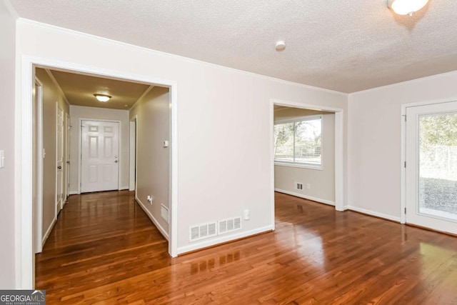 hall with dark hardwood / wood-style floors, a healthy amount of sunlight, and a textured ceiling