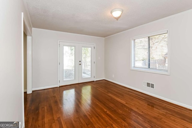 unfurnished room featuring dark hardwood / wood-style flooring, a textured ceiling, a wealth of natural light, and french doors