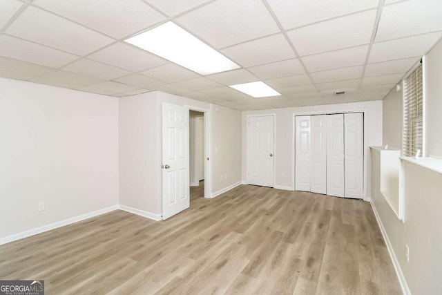 interior space featuring light hardwood / wood-style floors and a drop ceiling