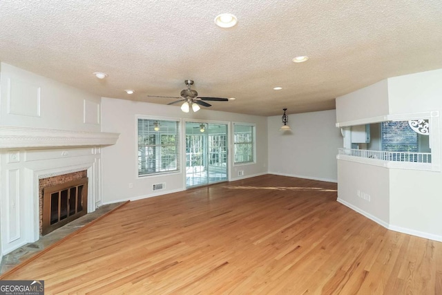 unfurnished living room with ceiling fan, light hardwood / wood-style floors, and a textured ceiling