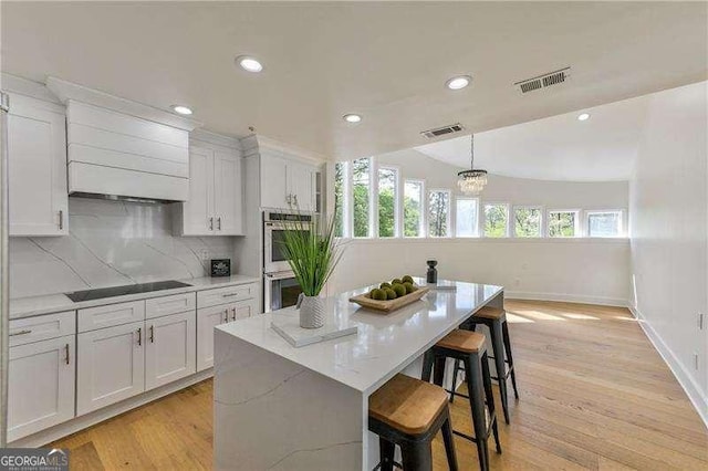 kitchen with black electric stovetop, white cabinetry, and double oven