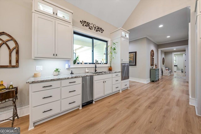 kitchen with wall oven, white cabinetry, sink, and stainless steel dishwasher