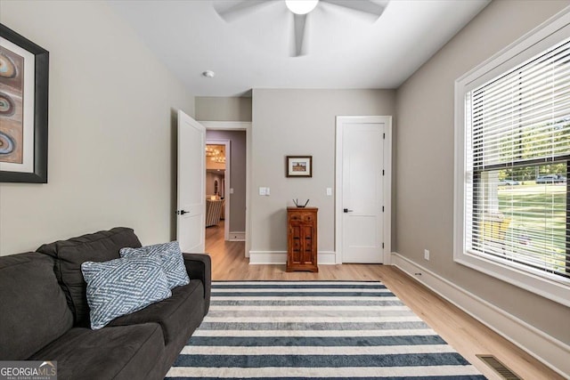 living area with light wood-type flooring and ceiling fan