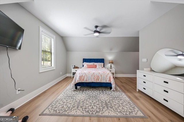 bedroom with ceiling fan, light hardwood / wood-style flooring, and lofted ceiling