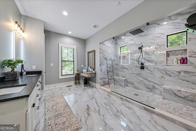 bathroom featuring tiled shower, vanity, and a healthy amount of sunlight