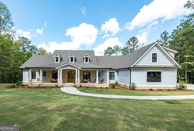 new england style home featuring covered porch and a front yard