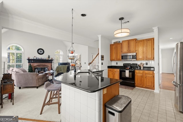 kitchen with a breakfast bar area, sink, hanging light fixtures, and appliances with stainless steel finishes