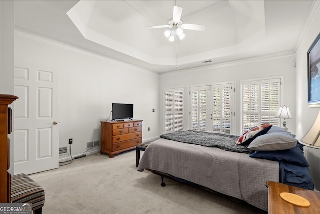 bedroom featuring a tray ceiling, ceiling fan, crown molding, and light colored carpet