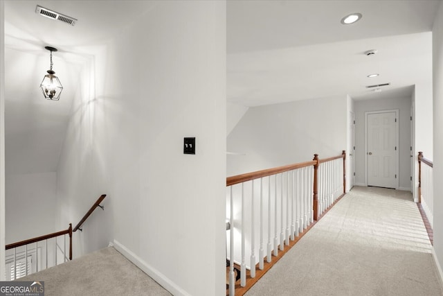 hall with light carpet and vaulted ceiling