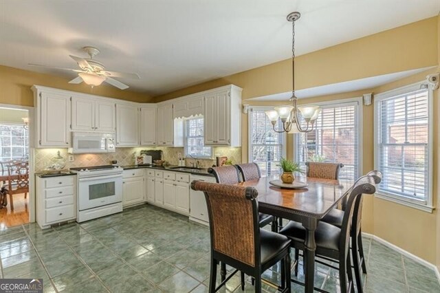 kitchen featuring dark countertops, white appliances, and plenty of natural light