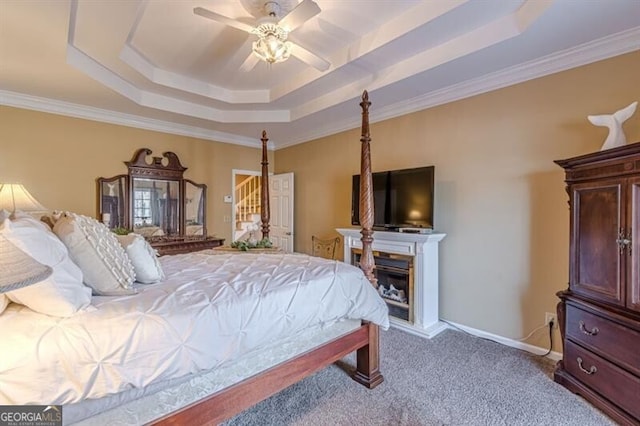 bedroom with a raised ceiling, baseboards, a ceiling fan, carpet floors, and ornamental molding