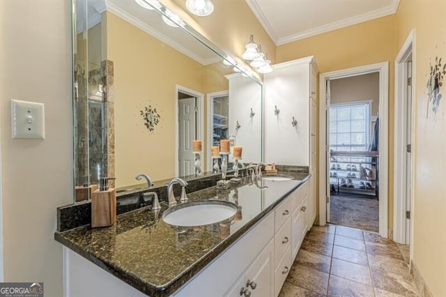 full bath with double vanity, crown molding, baseboards, and a sink