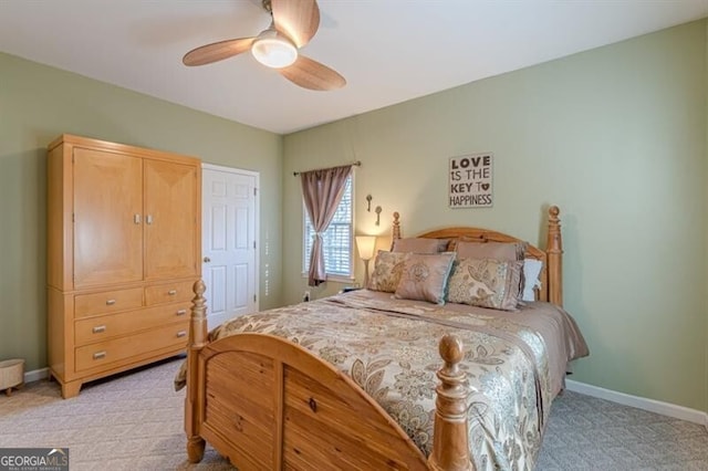 bedroom featuring light colored carpet, ceiling fan, and baseboards