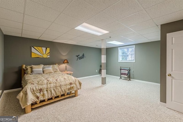 carpeted bedroom with baseboards and a drop ceiling