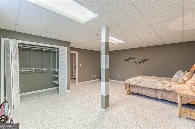 bedroom featuring baseboards, carpet flooring, and a drop ceiling