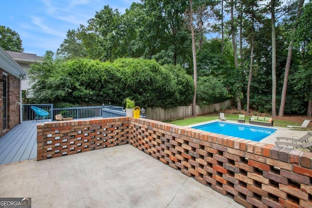 view of swimming pool featuring a deck and a patio area