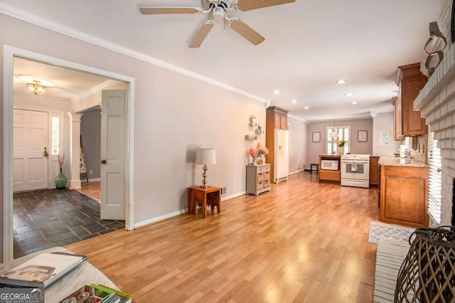 living room featuring ornate columns, ceiling fan, light hardwood / wood-style floors, and ornamental molding