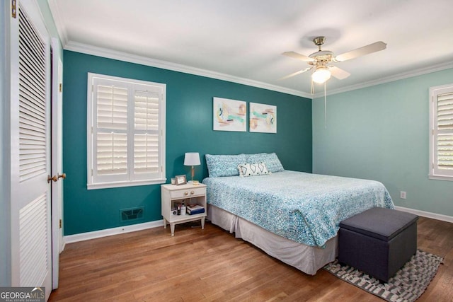 bedroom featuring hardwood / wood-style flooring, ceiling fan, and crown molding