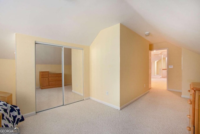 additional living space featuring light colored carpet and vaulted ceiling