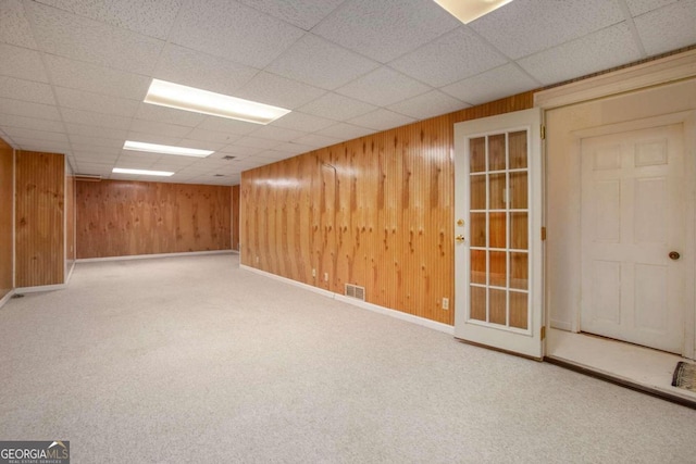 carpeted spare room featuring a drop ceiling