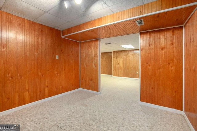 carpeted empty room with wooden walls