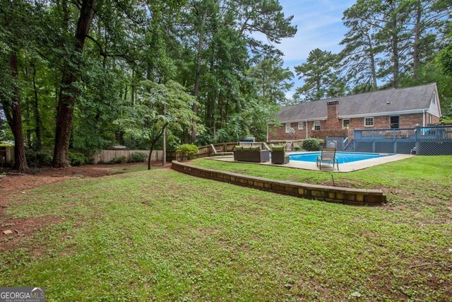 view of yard featuring outdoor lounge area and a swimming pool side deck