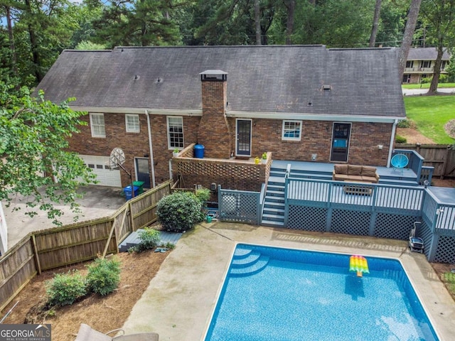 rear view of property featuring a swimming pool side deck