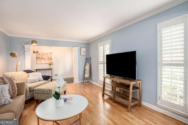 living room with light hardwood / wood-style floors, ornamental molding, and a wealth of natural light