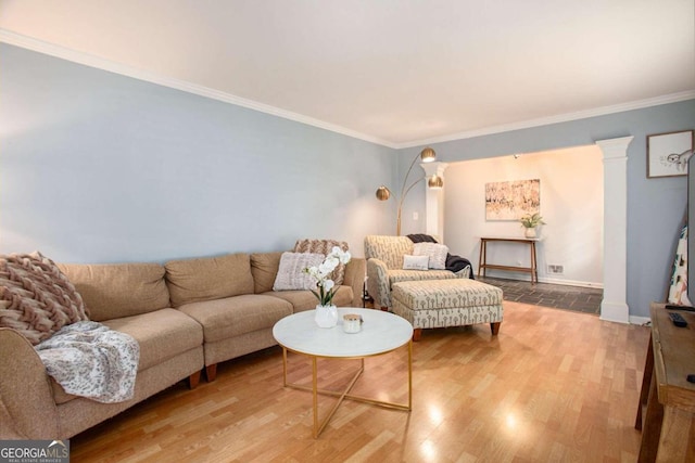 living room featuring hardwood / wood-style flooring, ornamental molding, and decorative columns