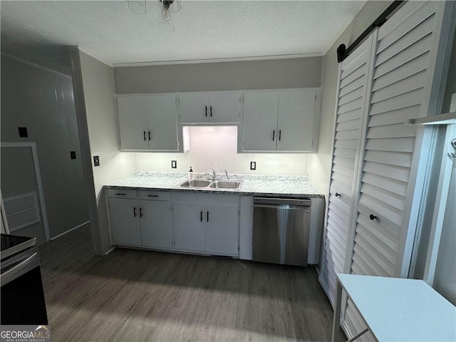 kitchen featuring dark wood-type flooring, white cabinets, sink, stainless steel dishwasher, and a barn door